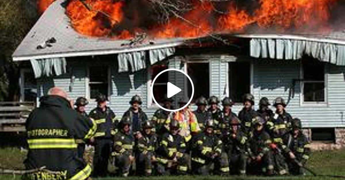 Возле пожарки. Пожарные на фоне горящего дома. Горящий дом. Пожарные фотографируются на фоне горящего дома. Пожарные на пожаре.